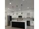 Modern kitchen with an island, stainless steel appliances, pendant lighting, and white cabinetry at 6344 Skyline Ct, Spring Hill, FL 34606