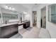 Bright bathroom features a walk-in shower, double vanity, granite countertops, and walk-in closet at 7133 Hatpin Loop, Wesley Chapel, FL 33545