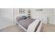 This bedroom has carpet, a window, neutral walls, a storage shelf and a white bedframe at 7133 Hatpin Loop, Wesley Chapel, FL 33545