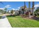 Attractive one-story home with a brick paver driveway, a three-car garage, and lush landscaping at 7133 Hatpin Loop, Wesley Chapel, FL 33545