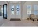 Spacious foyer with decorative glass doors, tile flooring, and abundant natural light at 7133 Hatpin Loop, Wesley Chapel, FL 33545