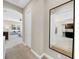 Hallway with a mirror leading into a living room and kitchen at 7133 Hatpin Loop, Wesley Chapel, FL 33545