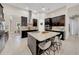 Modern kitchen with dark cabinets, large island with seating, and stainless steel appliances at 7133 Hatpin Loop, Wesley Chapel, FL 33545