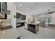Open kitchen features stainless steel appliances, dark cabinets, large island and breakfast bar at 7133 Hatpin Loop, Wesley Chapel, FL 33545