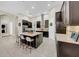 Modern kitchen with dark cabinets, large island with seating, and stainless steel appliances at 7133 Hatpin Loop, Wesley Chapel, FL 33545