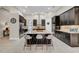 Modern kitchen with dark cabinets, large island with seating, and stainless steel appliances at 7133 Hatpin Loop, Wesley Chapel, FL 33545