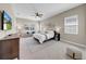Bright main bedroom with large windows, a ceiling fan, and a couch at 7133 Hatpin Loop, Wesley Chapel, FL 33545