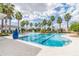 Resort-style community swimming pool featuring palm trees, ample seating, and clear, inviting water at 7133 Hatpin Loop, Wesley Chapel, FL 33545