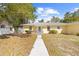 A welcoming single-story yellow house with a tidy front yard and a clean, concrete walkway to the entrance at 7183 Fireside St, Spring Hill, FL 34606