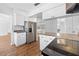 Cozy kitchen showcases stainless steel refrigerator, white cabinets, and wood flooring at 7183 Fireside St, Spring Hill, FL 34606