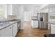 Well-lit kitchen offers stainless steel appliances, sleek cabinets, and durable wood flooring at 7183 Fireside St, Spring Hill, FL 34606
