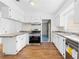 Well-lit kitchen with updated stainless steel appliances, wood-look floors, and white cabinetry at 7183 Fireside St, Spring Hill, FL 34606
