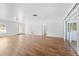 Large living room featuring wood-look floors, white walls, and access to a screened-in lanai at 7183 Fireside St, Spring Hill, FL 34606