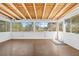 Bright sunroom with wood floors, white walls, and windows offering peaceful views of the surrounding greenery at 7183 Fireside St, Spring Hill, FL 34606