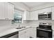 Well-lit kitchen with stainless steel appliances, including a microwave and range oven at 801 Chess Pl, Seffner, FL 33584