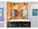 Bathroom with double sinks, modern vanity, unique lighting, and a marble enclosed shower at 810 22Nd N St, St Petersburg, FL 33713