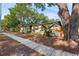 Street view of a single-story home with white brick, mature trees, and lush landscaping at 810 22Nd N St, St Petersburg, FL 33713