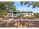 Charming single-story home featuring a brick exterior, lush landscaping, and a welcoming blue front door at 810 22Nd N St, St Petersburg, FL 33713