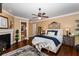 Comfortable bedroom with hardwood floors, fireplace, ceiling fan, and ensuite bathroom at 8711 Brooke Angela Dr, Odessa, FL 33556