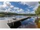 Private dock with sun loungers extending into the calm, reflective lake at 8711 Brooke Angela Dr, Odessa, FL 33556