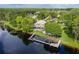Lakefront home with a private dock, lush lawn, mature trees, and serene water views from the property at 8711 Brooke Angela Dr, Odessa, FL 33556