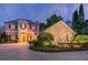 Elegant two-story home with stone accents, a paved driveway, manicured landscaping, and a charming fountain at 8711 Brooke Angela Dr, Odessa, FL 33556