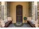 Cozy front porch featuring a decorative rug, benches with pillows, and stone detailing at 8711 Brooke Angela Dr, Odessa, FL 33556