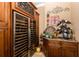 Elegant wine room with a wine refrigerator, custom cabinets, and granite countertop at 8711 Brooke Angela Dr, Odessa, FL 33556