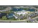 Aerial view of a community clubhouse with pools, tennis courts, and parking, highlighting community amenities at 8724 Ocean Tides Cv, Parrish, FL 34219