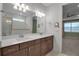 Bathroom featuring double vanity, walk-in shower, and entrance to bedroom at 8724 Ocean Tides Cv, Parrish, FL 34219