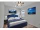 Bedroom with accent wall, ceiling fan, a queen sized bed, and natural lighting at 8724 Ocean Tides Cv, Parrish, FL 34219