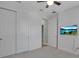 Bright bedroom features a ceiling fan, flat screen tv, and closet with white panel doors at 8724 Ocean Tides Cv, Parrish, FL 34219