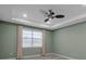 Bedroom with ceiling fan, window with blinds, and green walls at 8724 Ocean Tides Cv, Parrish, FL 34219