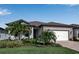 Beautiful single-story home featuring stone accents, manicured lawn, and a two-car garage at 8724 Ocean Tides Cv, Parrish, FL 34219