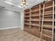 Office with wood floors, built in shelving with ladder, modern chandelier, and neutral paint at 8724 Ocean Tides Cv, Parrish, FL 34219