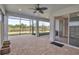 Screened-in patio with ceiling fan and backyard view to the green landscape at 8724 Ocean Tides Cv, Parrish, FL 34219