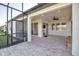 Spacious covered patio featuring neutral stone flooring, ceiling fan, and multiple access points to home at 8724 Ocean Tides Cv, Parrish, FL 34219