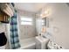 Tiled bathroom featuring a shower-tub combo with blue striped shower curtain, white sink and toilet and decorative mirror at 9048 94Th St, Seminole, FL 33777