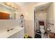 Neutral bathroom with tiled walls, updated vanity, storage shelving, and accessible walk-in shower with safety bars at 9048 94Th St, Seminole, FL 33777