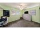 Bedroom featuring light green walls, window, carpeted floor, ceiling fan, and a television mounted on the wall at 9048 94Th St, Seminole, FL 33777