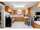 View of a kitchen with light oak cabinets, white appliances, and tiled floors at 9048 94Th St, Seminole, FL 33777