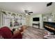 Bright living room with laminate floors, a ceiling fan, and a cozy fireplace at 9048 94Th St, Seminole, FL 33777