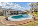 Backyard oasis featuring a kidney-shaped pool, covered patio, and landscaped surroundings at 917 Silver Ridge Way, Valrico, FL 33594