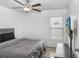 Bright bedroom with ceiling fan, window with blinds, gray headboard, and wall-mounted TV at 9412 Lemon Drop Loop, Ruskin, FL 33573