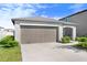 Attached two-car garage and a well-manicured lawn at 9412 Lemon Drop Loop, Ruskin, FL 33573