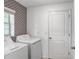 Practical laundry room with white washer and dryer units and a window with natural light at 9412 Lemon Drop Loop, Ruskin, FL 33573