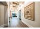 Hallway view showing dark hardwood flooring, modern lights, and decorative wall art at 9639 Minnow Ray Dr, Land O Lakes, FL 34638