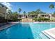 Beautiful community pool area with palm trees and comfortable lounge chairs for relaxing at 10201 Courtney Palms Blvd # 204, Tampa, FL 33619