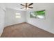 Bright bedroom with large windows, ceiling fan, and neutral carpeting at 10323 107Th N Ave, Largo, FL 33773