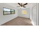 Sunlit bedroom with a ceiling fan, plush carpeting, and two windows offering natural light at 10323 107Th N Ave, Largo, FL 33773